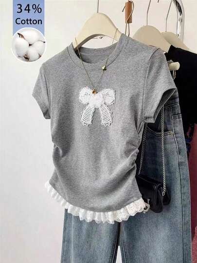 Camiseta feminina de manga curta com gola redonda, detalhe de laço e babados, ideal para uso casual e diário.