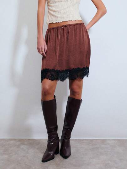 Nöista Brown Satin Mini Skirt With A Black Lace Trim Hem And An Elastic Waistband With A Small Bow. Night Out, Festival, Spring, Summer, Woman.