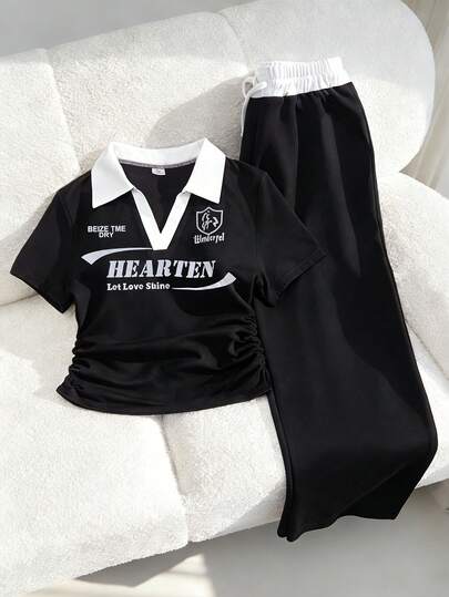 Genç kızlar için tasarlanmış, polo yakalı, kontrast dikişli, göğüs kısmı işlemeli, pileli bel detaylı kısa kollu üst ve geniş paçalı, büzgülü bel pantolondan oluşan günlük spor takımı. Bu lacivert spor takımı, konfor ve stili mükemmel bir şekilde dengeliyor. Zarif ama sade olan, ayarlanabilir bel detaylı geniş paçalı pantolon ve kontrast polo yaka, boyun çizgisini vurgulayarak, evde dinlenme, spor veya dış mekan giyimi için vazgeçilmez bir yaz kıyafeti haline geliyor.