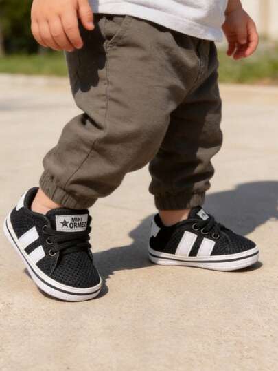 Tenis para bebé estilo casual con agujetas decorativas, calzado infantil ligero y cómodo, ideal para uso diario, sesiones fotográficas y salidas familiares, diseño clásico tipo urbano, suela flexible para etapa inicial, interior suave para pies pequeños, fácil de combinar con conjuntos infantiles, opción práctica para guardería, paseos y eventos especiales