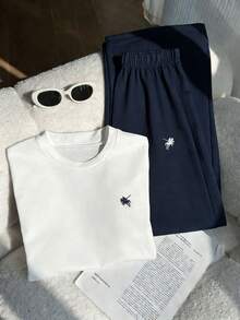 SHEIN 这款女童两件套，时尚休闲又不失运动感。白色圆领短袖套头衫采用舒适弹力针织面料，搭配藏蓝色宽松直筒裤。上衣和裤子正面均饰有独特的刺绣。整体设计休闲时尚，适合日常穿着、室内外活动，甚至春夏季节也同样适用。 - 彩色 - 查看 9