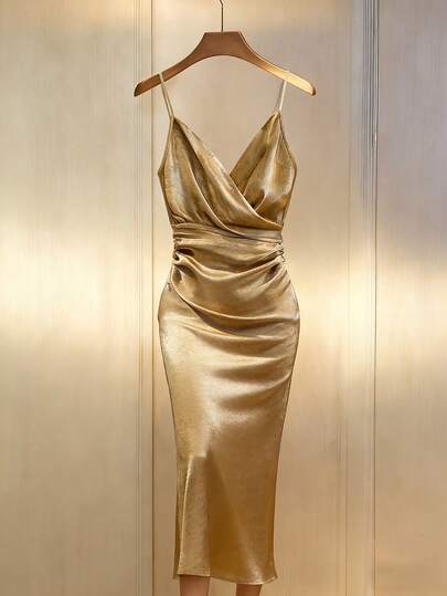 Franclia 【金色收腰吊带美人鱼礼服】缎面面料搭配褶裥纹理，尽显高端质感。深V领搭配交叉绑带，恰到好处地展现肌肤。收腰褶裥设计凸显身材曲线，巧妙遮掩腰部赘肉。飘逸摇曳的裙摆，搭配高跟鞋，是约会或晚宴的理想之选；也可搭配披肩，出席正式场合。这款礼服既能惊艳全场，又不会显得过于张扬。