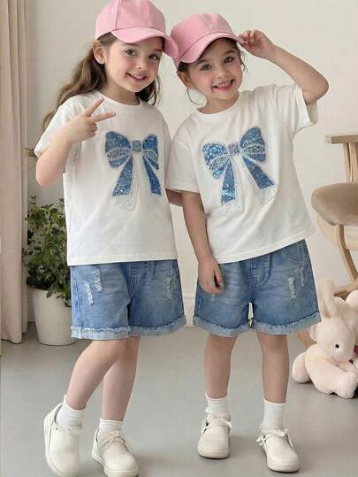 Set de 2 piezas: Camiseta de manga corta blanca de cuello redondo y pantalones cortos de mezclilla rasgados para niñas pequeñas, conjunto casual de verano