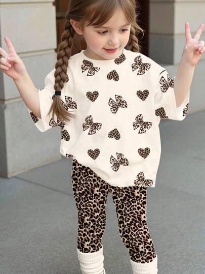 SHEIN Cream White & Sweet Retro Leopard Bow, Cute Leopard Heart Print Pattern, Sister & Best Friend Set, Baby Girl Casual Loose Round Neck Short Sleeve T-Shirt And Skinny Leggings Set, Suitable For Spring/Summer, Cute Summer Outfits Summer Kids Items, Summer Outing Items, Korean Style, Easy Comfort, Stylish Kids, Y2K, Kawaii, Party, Everyday, Vacation, Cute, Comfy, Summer 2026, Cottagecore, Weekend Casual, Family Outing, Photoshoot Outfits, Chill Chill, Baby & Kids Graphic Tee Set