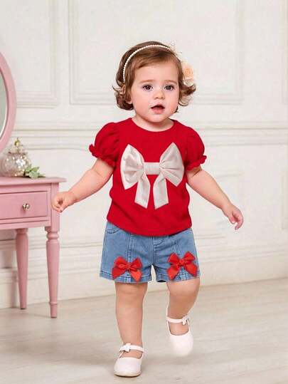 SHEIN 2pcs Baby Girl Summer Fashion Streetwear Sweet Red Round Neck Puff Sleeve Top With Apricot Bow Decor, Paired With Blue Denim Shorts With Red Ribbon Bow Decor, Suitable For Party, Streetwear, School, And Photoshoot