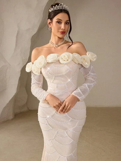 Coutiva Chiếc váy dạ hội thanh lịch với thiết kế đính sequin hình quạt, cổ trễ vai, điểm nhấn là những bông hồng ba chiều, vai rủ, tay dài và chân váy kiểu đuôi cá, tạo nên một bộ váy trang trọng phù hợp cho khách dự đám cưới, lễ khai trương và lễ tốt nghiệp.