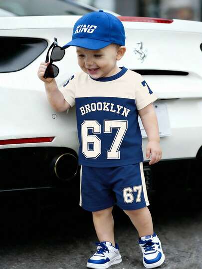 男婴休闲运动套装（两件套），圆领短袖T恤印有品牌标志和数字，搭配数字印花短裤，适合夏季外出穿着。