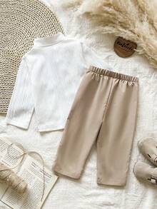 SHEIN Vintaside Kids 这款男童两件套包含一件蓝色提花立领长袖衬衫和一条白色直筒裤，适合春秋季穿着，展现精致优雅的传统中式风格。款式百搭，复古时尚，又不失正式感。宽松的版型、左胸口袋设计和立领设计都散发着浓郁的中国风情。适合日常上学、参加聚会、居家休闲以及正式场合穿着。 - 杏色 - 查看 2