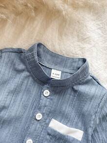 SHEIN Vintaside Kids 这款男童两件套包含一件蓝色提花立领长袖衬衫和一条白色直筒裤，适合春秋季穿着，展现精致优雅的传统中式风格。款式百搭，复古时尚，又不失正式感。宽松的版型、左胸口袋设计和立领设计都散发着浓郁的中国风情。适合日常上学、参加聚会、居家休闲以及正式场合穿着。 - 霧霾藍 - 查看 6