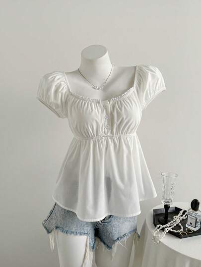 SHEIN 这款时尚休闲的白色短袖上衣专为少女设计，采用半开襟设计，领口饰有精致蕾丝花边，经典方领，甜美的泡泡袖，以及前襟精致的纽扣，方便穿脱。可调节腰身和A字下摆，尽显娃娃衫的童趣魅力。适合日常穿着、上学、旅行等各种场合，是春夏的理想之选。