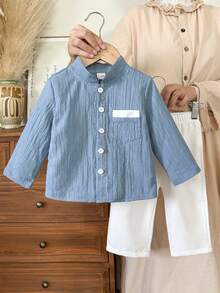 SHEIN Vintaside Kids 这款男童两件套包含一件蓝色提花立领长袖衬衫和一条白色直筒裤，适合春秋季穿着，展现精致优雅的传统中式风格。款式百搭，复古时尚，又不失正式感。宽松的版型、左胸口袋设计和立领设计都散发着浓郁的中国风情。适合日常上学、参加聚会、居家休闲以及正式场合穿着。 - 霧霾藍 - 查看 5