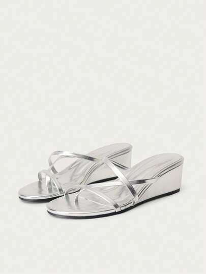 Nöista Metallic Silver Wedge Sandals With Asymmetrical Straps And A Sleek Thong Silhouette-A Futuristic, High-Shine Option For Summer Guest Attire, Eid Parties, Or A Vibrant Festival Look.