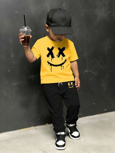 SHEIN 2pcs/Set Toddler Boys' Outfit: Short Sleeve Face Print Yellow T-Shirt + Black Pants Set, Kid Essential, Comfortable Street Style, Versatile Casual Outfit For All Seasons