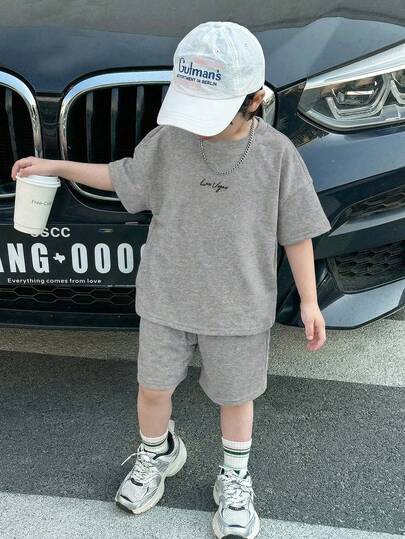 SHEIN Bộ đồ cho bé trai mới về, phong cách Y2K tối giản, thoải mái, in chữ tiếng Anh, thể thao, cơ bản, đa năng, màu xám nhạt, áo thun tay ngắn cổ tròn và quần short rộng rãi, thoải mái, thích hợp cho mùa hè.