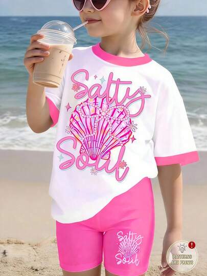 Set de 2 piezas de estilo casual y dulce para vacaciones en la playa para niñas jóvenes, con camiseta de manga corta y pantalones cortos pitillo, con texto en inglés, lazo de perlas, estampado de conchas en la camiseta rosa y los pantalones, adecuado para primavera/verano, edades 4-7