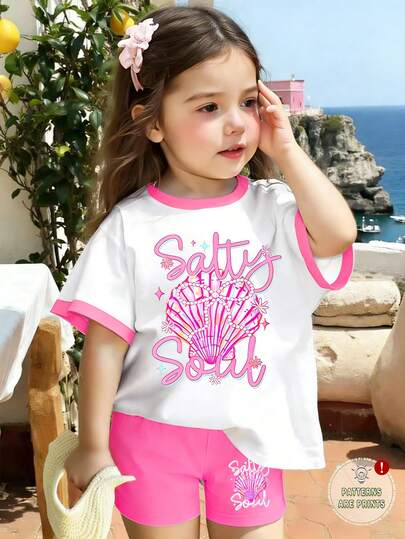 Set de 2 piezas de estilo casual y dulce para vacaciones en la playa para niñas jóvenes, con camiseta de manga corta y pantalones cortos pitillo, con texto en inglés, lazo de perlas, estampado de conchas en la camiseta rosa y los pantalones, adecuado para primavera/verano, edades 4-7