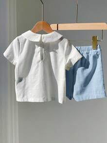 SHEIN Bộ đồ 2 món cho bé trai mùa hè, kiểu dáng thường ngày, dễ thương, màu trắng in họa tiết, cổ búp bê, tay ngắn và quần short cạp chun, thích hợp cho tiệc sinh nhật, tiệc rave, tiệc tối, biểu diễn, đám cưới, tiệc mừng em bé và lễ kỷ niệm sinh nhật lần thứ nhất. - Màu xanh lam - Xem 2