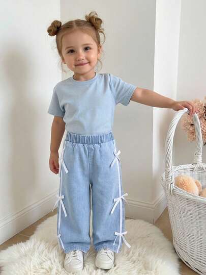 2026新款女婴时尚白色蝴蝶结装饰直筒修身牛仔裤，柔软舒适的浅蓝色水洗牛仔面料，适合日常穿着、户外玩耍、派对和庆祝活动。