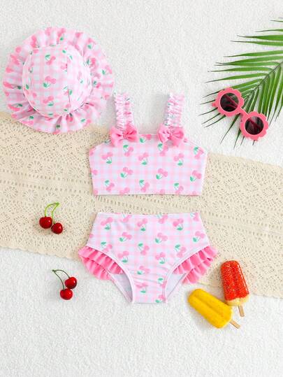 Baby Girls Beachwear: This Playful Multi-Color Small Cherry Pink Checkered Print Knitted Fabric Top Features Shoulder Straps With Bows And Lace At The Hem. It Comes In A Three-Piece Set  Separate Top Triangle Swimming Trunks + Swimming Cap. Perfect For A Stylish, Casual, Elegant And Ladylike Summer Vacation At The Beach, Pool, Or Any Outdoor Swimming Area. Suitable For Summer Parties, Leisure Vacations, And The Summer Break.