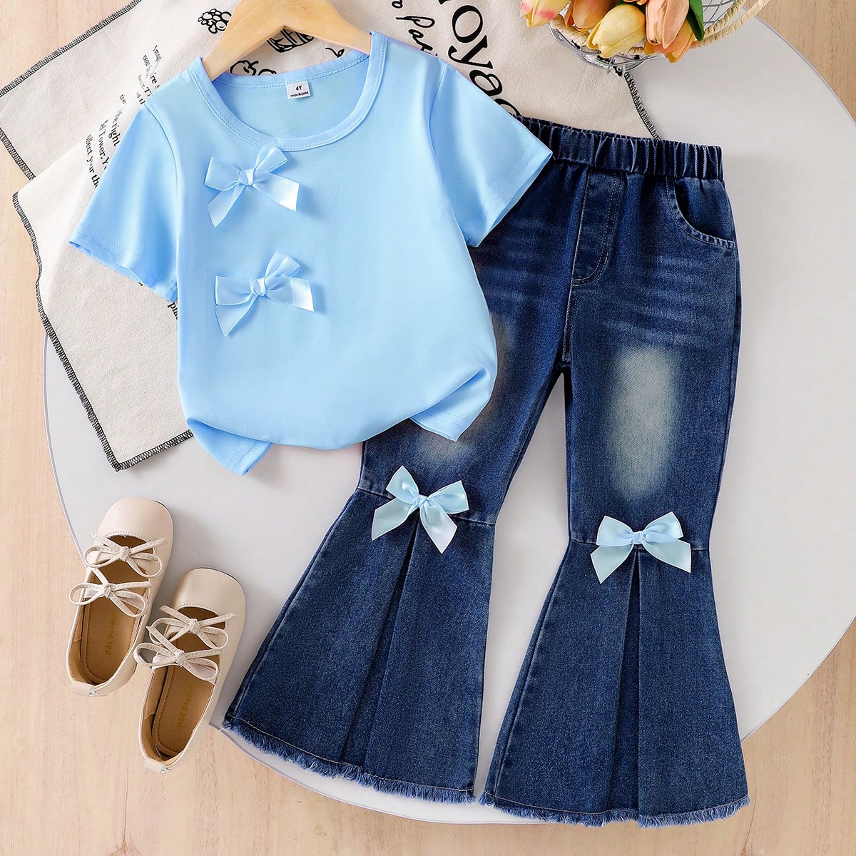 Set de 2 piezas para niñas (talla pequeña) que incluye blusa de punto azul de manga corta con lazo y pantalones vaqueros acampanados con bolsillos,