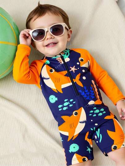 婴儿拉链泳衣，海洋生物鲨鱼印花。夏季海滩度假必备时尚单品。长袖设计，蓝色撞色，可爱的鲨鱼和海洋生物卡通图案。生动活泼。适合可爱的男宝宝在海滩玩耍时穿着。