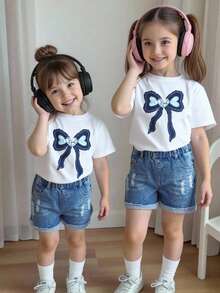 Bộ 2 món cho bé gái mùa hè, gồm áo thun trắng tay ngắn cổ tròn thắt nơ và quần short denim rách, kiểu dáng thường ngày. - Nhiều màu - Xem 2