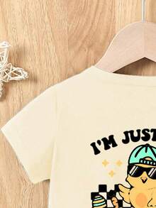 SHEIN 男婴休闲时尚创意可爱圆领修身针织T恤,印有“我只是来陪小鸡的”复活节小鸡和彩蛋字母图案,适合春夏穿着。 - 杏色 - 查看 6