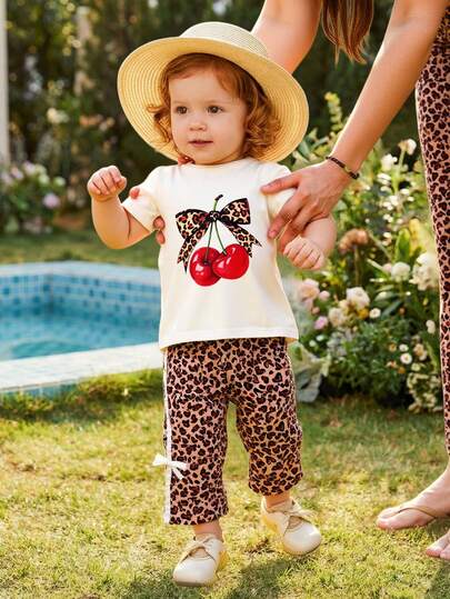 SHEIN 两件套夏季女童休闲复古时尚白色圆领短袖T恤上衣，饰有豹纹蝴蝶结和樱桃印花，搭配心形豹纹长裤，适合街头、学校和日常穿着。