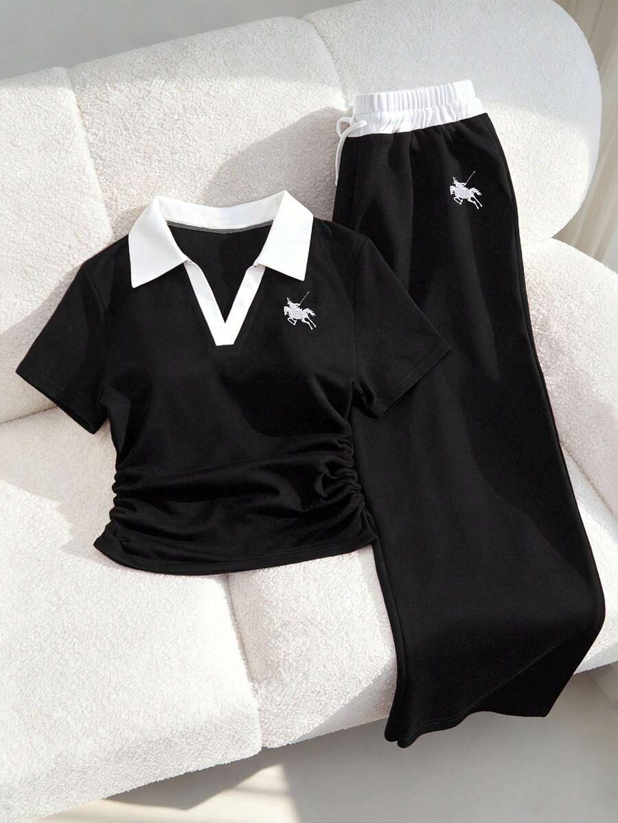 SHEIN 这款少女休闲运动套装，采用撞色缝线 Polo 领设计，胸前饰有刺绣，短袖上衣腰部设有褶裥，搭配阔腿抽绳裤。海军蓝配色，完美兼顾舒适与时尚。简约而不失精致，可调节腰围的阔腿裤和撞色 Polo 领更能衬托颈部线条。是居家休闲、运动健身或户外活动的必备夏季单品。 - 黑色 - 查看 1
