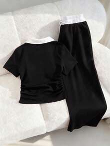 SHEIN 这款少女休闲运动套装，采用撞色缝线 Polo 领设计，胸前饰有刺绣，短袖上衣腰部设有褶裥，搭配阔腿抽绳裤。海军蓝配色，完美兼顾舒适与时尚。简约而不失精致，可调节腰围的阔腿裤和撞色 Polo 领更能衬托颈部线条。是居家休闲、运动健身或户外活动的必备夏季单品。 - 黑色 - 查看 2