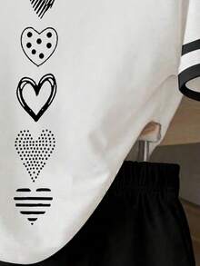 Bộ 2 món cho bé gái tuổi teen: áo thun kẻ sọc đen và áo croptop in hình trái tim đen, kèm quần short đen, thích hợp cho các hoạt động ngoài trời, mùa xuân, hè, thu. Áo thun ôm eo, quần short cơ bản. - Nhiều màu - Xem 3