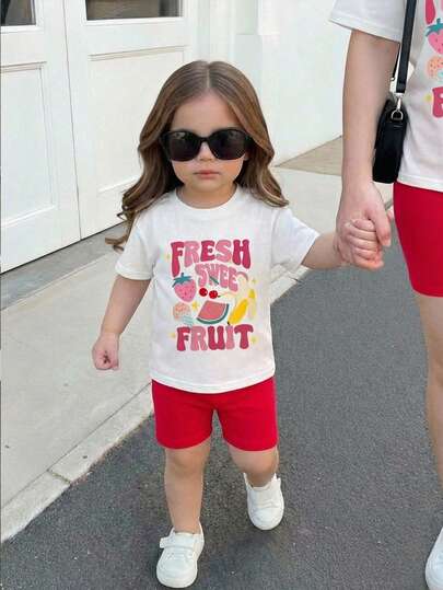 SHEIN 这款两件套可爱女婴休闲简约针织弹力涂鸦水果图案白色T恤和紧身短裤套装，适合生日派对、聚会、表演、婚礼、洗礼、开幕式、日常穿着、学校、郊游以及春夏季节。