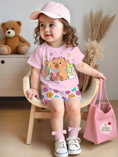 SHEIN Set de 2 piezas de camiseta de manga corta de cuello redondo y pantalones cortos de licra para niña bebé, con estampado de capibara de dibujos animados y flores coloridas en crema y rosa, adecuado para primavera/verano, uso diario, vacaciones y viajes