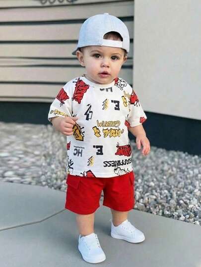 SHEIN Conjunto de 2 piezas de verano para niños pequeños, un conjunto de moda con estampado de letras de dibujos animados en la Top de manga corta y pantalones cortos de unicolor, alegre y lindo, adecuado para actividades al aire libre, uso cómodo en casa y reuniones casuales