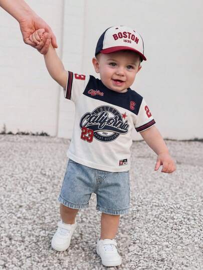 SHEIN 两件套男婴运动休闲套装，包括一件红蓝字母印花宽松短袖上衣和一条蓝色牛仔短裤，适合春夏户外、运动、旅行和度假穿着。