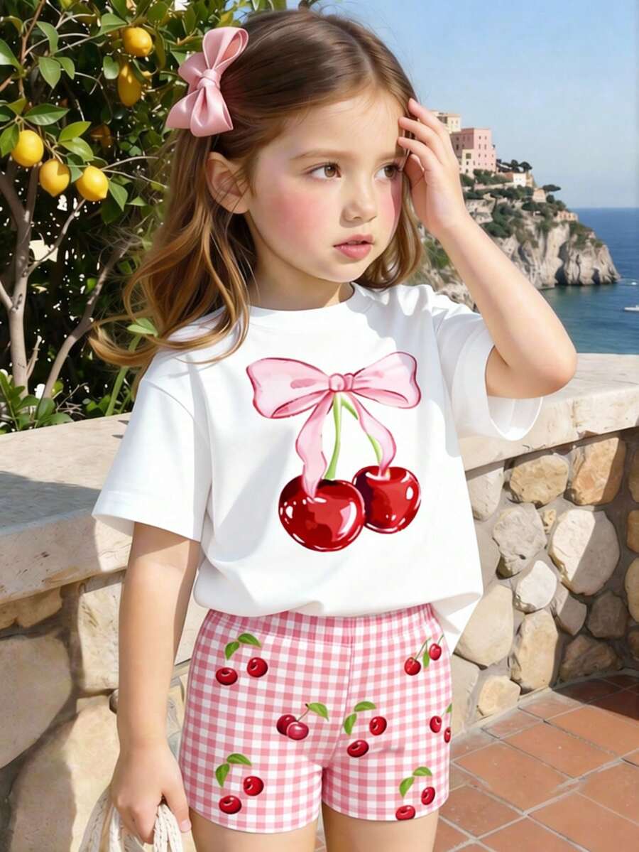 Souflis Souflis Bộ 2 món cho bé gái, gồm áo thun ngắn tay in hình quả anh đào và nơ xinh xắn, cùng quần short kẻ caro hồng trắng, thích hợp cho các hoạt động ngoài trời mùa hè. - Nhiều màu - Xem 1