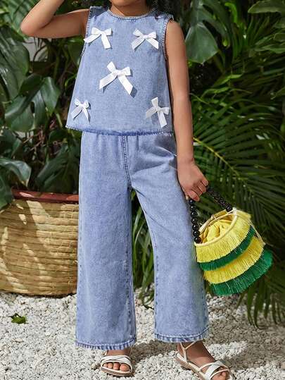 Bộ 2 món gồm áo tank top trắng có nơ rộng và quần jean xanh nhạt dáng rộng cho bé gái.