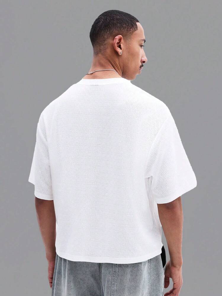 胸に文字が入った白いオーバーサイズTシャツ