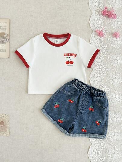 Bộ đồ thường ngày dễ thương cho bé gái gồm 2 món: Áo thun ngắn tay cổ tròn in hình quả anh đào phối màu tương phản + Quần short denim cạp chun gấu xắn có thêu hình quả anh đào.