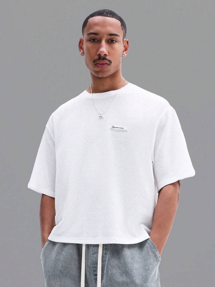 胸に文字が入った白いオーバーサイズTシャツ