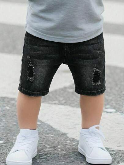Pantalones cortos negros de mezclilla elástica y ajustada con roturas para niño