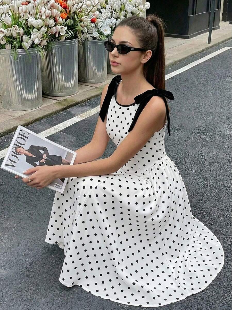 Họa tiết chấm bi cổ điển, mang hơi hướng retro và trẻ trung; dây đeo vai nơ đen, ngọt ngào và tinh tế; dáng váy xòe ôm eo, tôn dáng; chất liệu mềm mại, phù hợp cho mặc hàng ngày, hẹn hò và dự tiệc, toát lên vẻ thanh lịch. - Đen và trắng - Xem 1