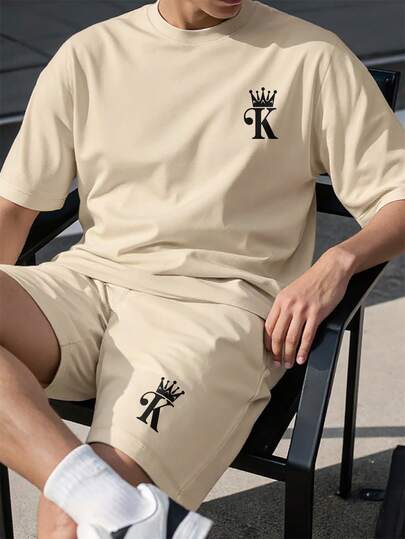 Manfinity Homme Bộ 2 món gồm áo thun ngắn tay cổ tròn in chữ và quần short nam, thích hợp mặc mùa hè.