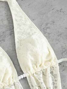 Swim SXY 这款女士欧美风性感大胆前卫的日常法式度假百搭泳衣套装，采用米白色蕾丝面料，饰以串珠配饰，系带露背吊带深V设计，搭配后背褶皱泳裤和外层蕾丝裙，三件套设计，适合春假、秋季返校季、啤酒节、音乐节、春季促销、海滩度假、春季派对、情人节等场合。 - 杏色 - 查看 6