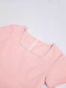 Ellegaria. 女士优雅时尚珍珠装饰方领连衣裙【柔粉色珍珠领腰连衣裙】柔雾粉色缎面面料，散发着温柔气质；领口饰以精致高贵的珍珠，低调而不失优雅；短袖遮掩手臂赘肉，高腰褶裥设计收紧腰身，蓬松裙摆垂坠顺滑无褶皱，行走轻盈飘逸。搭配平底鞋，打造优雅日常约会造型，也适合轻松的社交场合，尤其适合黄调肤色。适合派对、度假、节日穿着。粉色优雅连衣裙 优雅中长连衣裙 下午茶连衣裙 经典连衣裙 优雅春季连衣裙 女士吸睛连衣裙 惊艳连衣裙 职场穿搭 女士优雅套装 女士连衣裙 正式礼服 常规尺码女士连衣裙 女士正式经典连衣裙 高品质连衣裙 - 黑與白 - 查看 6