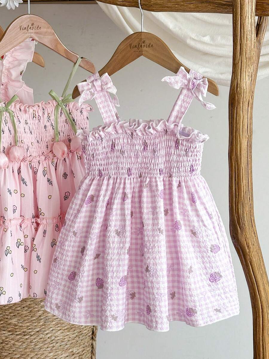 SHEIN Vintaside Kids 这款女童夏季粉色格子吊带连衣裙,以柔和的粉色格子为底色,点缀着新鲜草莓图案,可爱俏皮,散发着甜美乡村公主风情。连衣裙采用梭织面料,A字版型,肩带上的蝴蝶结装饰灵动可爱。适合草莓园拍照、校园活动、居家休闲、度假旅行以及参加派对等各种场合。 - 彩色 - 查看 1
