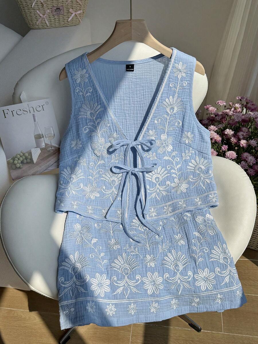 Comfortcana Bộ áo hai dây và chân váy ngắn màu xanh nhạt thêu hoa, thắt nơ phía trước dành cho nữ. - Màu xanh nhạt - Xem 1