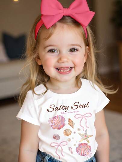 SHEIN 奶油白，Salty Soul 甜美海星贝壳珍珠蝴蝶结图案T恤，女婴休闲简约短袖圆领T恤，适合春夏日常、街头风、外出、度假、返校等场合，春夏女童外出穿搭，轻松舒适，春夏女童套装，时尚女童，休闲装，女婴海滩度假图案T恤，春夏时尚，休闲风格，轻松别致，轻松惬意穿搭，轻松休闲风