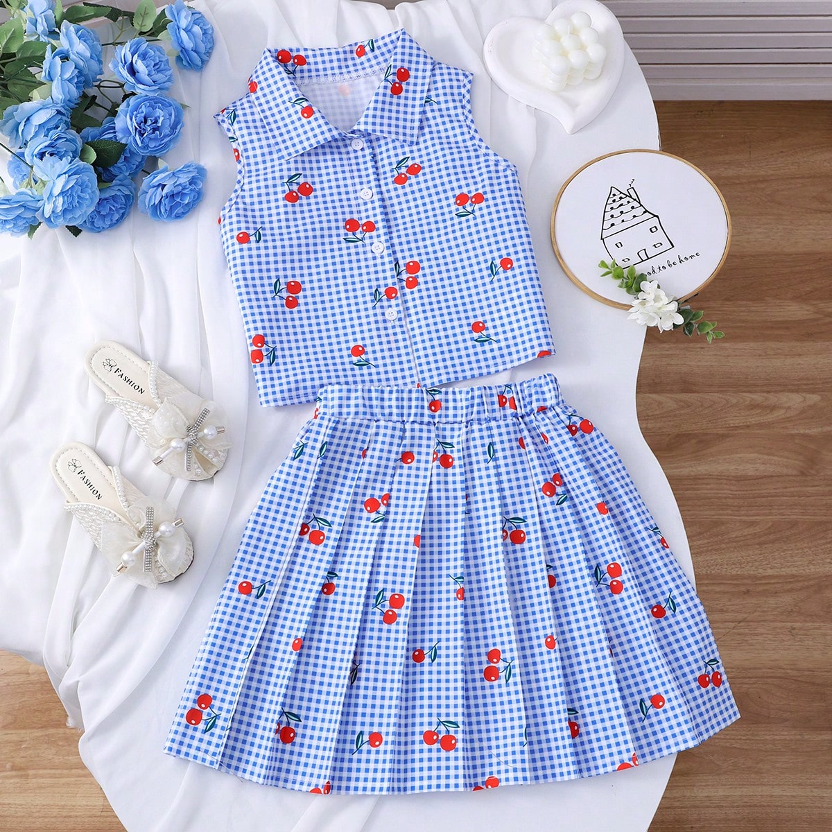 Set de 2 piezas con camisa sin mangas con estampado de cuadros azules y cerezas, combinada con falda plisada a cuadros, adecuado para salidas de prima