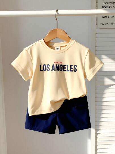 SHEIN Bộ áo thun cho bé trai, bộ đồ thể thao thường ngày cho bé trai sơ sinh, áo thun cổ tròn tay ngắn dáng rộng màu xanh hải quân in chữ tiếng Anh kết hợp với quần short thể thao màu xanh hải quân trơn có túi hộp, quần áo trẻ em, bộ đồ cho trẻ sơ sinh và trẻ nhỏ, bộ đồ thể thao cho bé trai sơ sinh và trẻ nhỏ, bộ quần short tay ngắn cho bé trai sơ sinh và trẻ nhỏ, thích hợp mặc vào mùa xuân/hè, đi nghỉ mát, dự tiệc, chất liệu mềm mại thoải mái, thời trang mới mùa xuân/hè 2026, Nueva Moda SS26, đồ cần thiết cho kỳ nghỉ, du lịch, trang phục mùa hè.